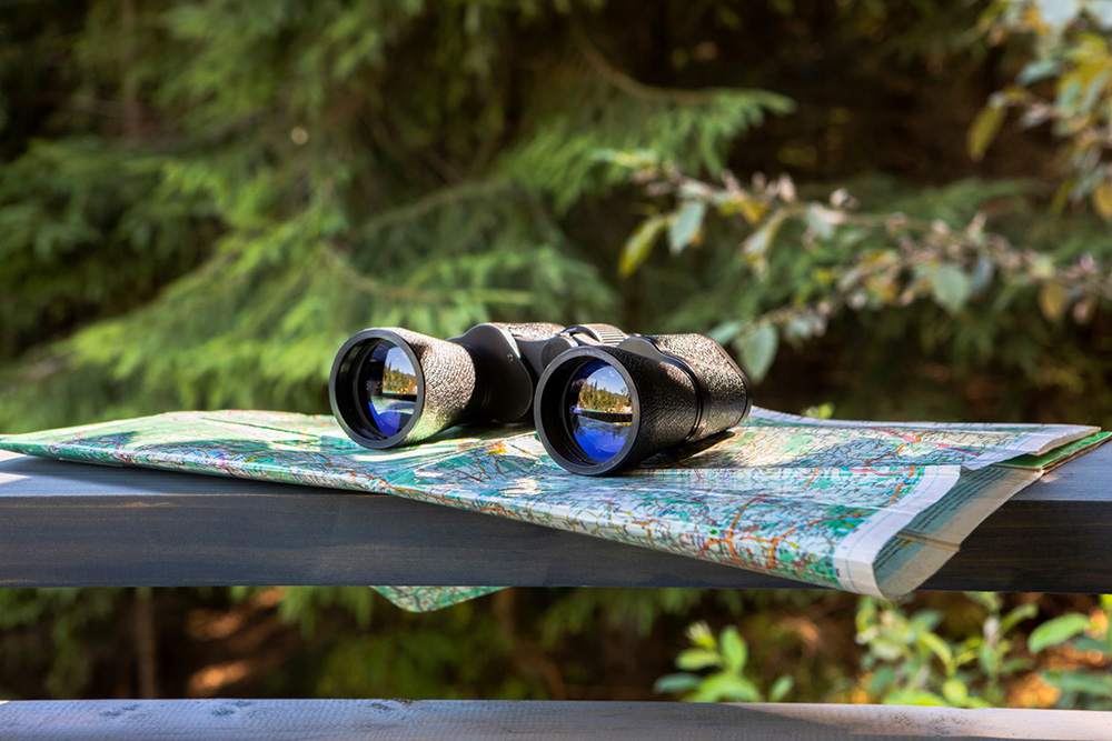 binoculars sitting on a map outdoors