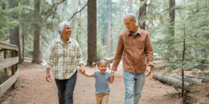 Vibrant multiracial senior couple hiking with their young granddaughter