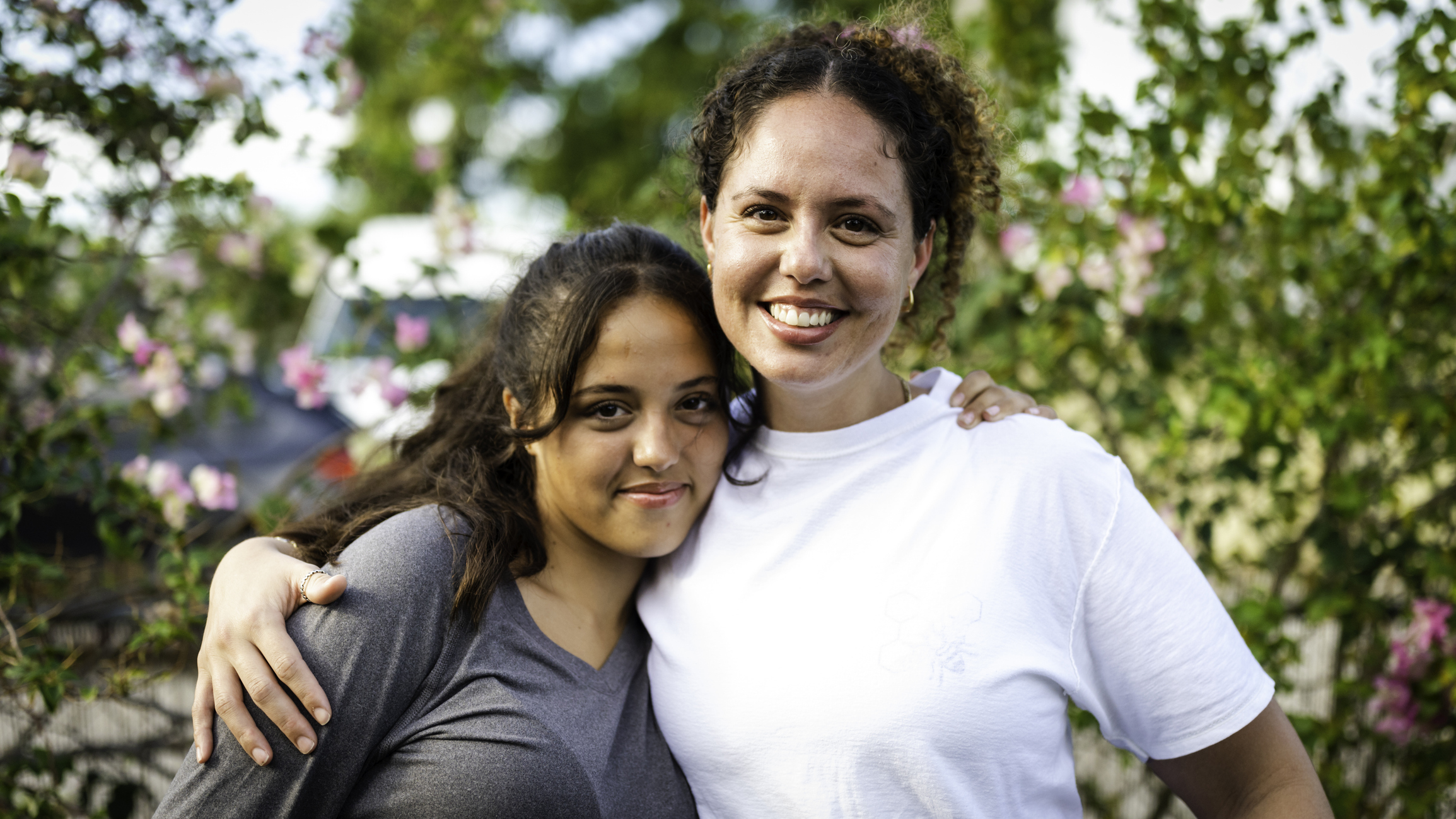 Happy cute outdoor portrait of Latina mother and teenage daughter, two beautiful women together with affection